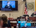 A man on a monitor is displayed in a courtroom