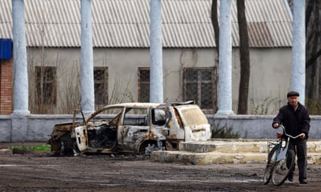 A man is seen near a burned out car in Chasiv Yar, close to the frontline in Bakhmut.