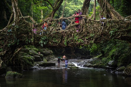 Tourists pose for photographs on a living root bridge in Mawlynnong, Meghalaya.