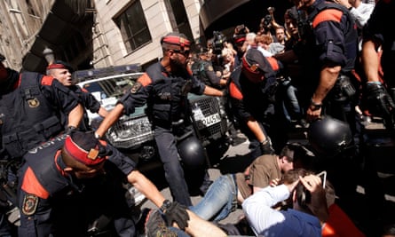 Catalan police officers try to disperse protesters in Barcelona