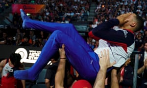 Joe Fraser celebrates with his teammates after winning the parallel bars final at the world championships.