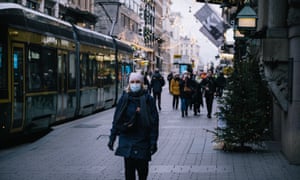 A woman wears a protective face mask in Helsinki, Finland, as the country announces it will significantly scale up Covid restrictions on the hospitality industry from Christmas Eve.