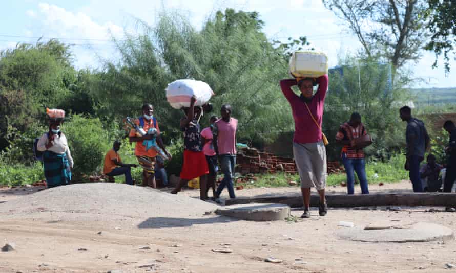 Women carrying goods on their head on a riverbank