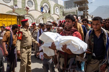 A Yemeni man carries the body of a child killed in a reported mortar shell attack during fighting between Houthi rebels and the Yemeni forces, February 2022.