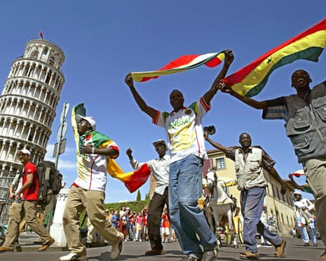 Senegal fans wave their national flags as they celebrate in front of Pisa's leaning tower in Italy