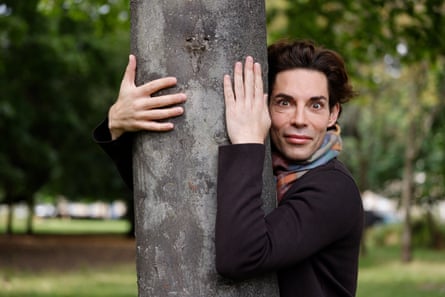 A man hugging a tree in a park