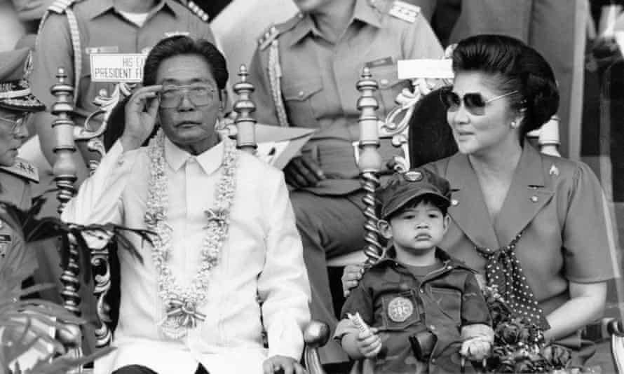 Ferdinand Marcos Sr, and his second wife, Imelda, watch thousand of university students undergo compulsory military training in Manila in 1985.