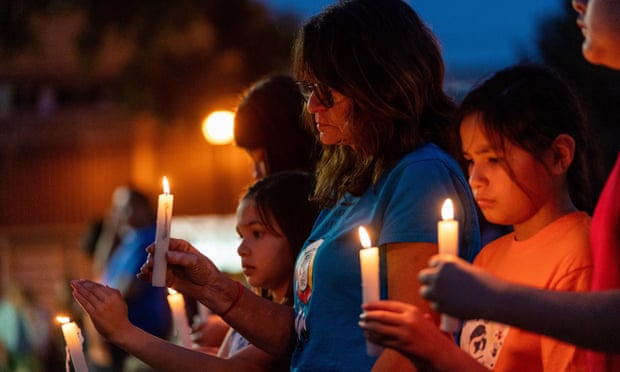 People hold candles at a vigil remembering the stabbing victims in front of City Hall in Prince Albert, Saskatchewan.