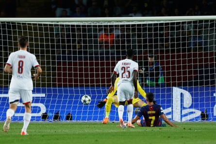 Ferran Torres, on the ground, scores the opening goal for Barcelona against PSG.
