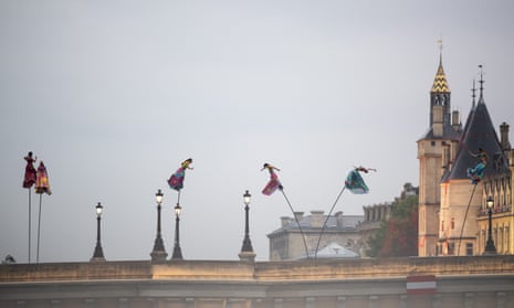 Dangling dancers on poles on a bridge