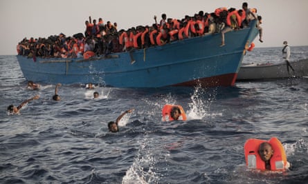 Migrants, most from Eritrea, jump into the water during a rescue operation off Libya in August.