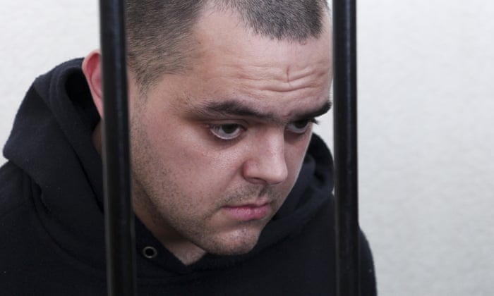 British citizen Aiden Aslin stands behind bars in a courtroom in Donetsk, in June 2022