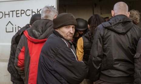 Residents wait to receive aid packages in the frontline city of Avdiivka