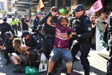 Police arrest Extinction Rebellion protesters after they blocked the corner of Edward and Queen streets in Brisbane.