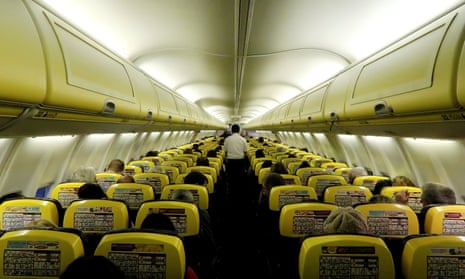 A cabin crew member serves passengers onboard a Ryanair flight