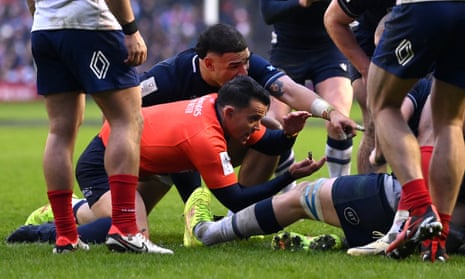 Referee Nic Berry signals that the ball is held up, denying Sam Skinner of Scotland (obscured) a try against France.