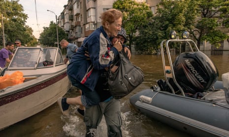 A man carries an elderly woman evacuated from a flooded area in Kherson, Ukraine.