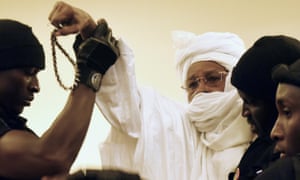Former Chadian dictator Hissène Habré is escorted by prison guards into a courtroom in Dakar.