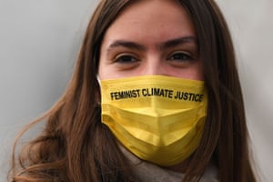 A delegate wearing a face covering reading 'Feminist climate justice' attends the third day of Cop26.