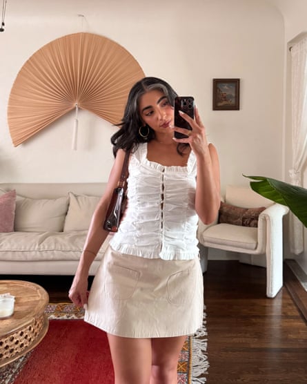 A young woman takes a mirror selfie in her apartment