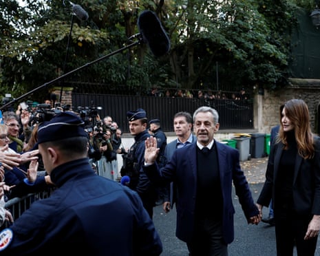 Former French president Nicolas Sarkozy waves to supporters as he leaves his house with his wife, Carla Bruni-Sarkozy in Paris, France, 21 October 2025.