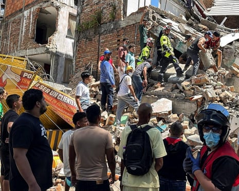 Residents and emergency personnel dig through the debris of a partially collapsed building.