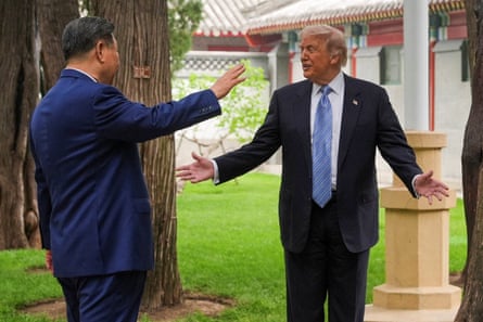 two men in suits gesticulate in a garden
