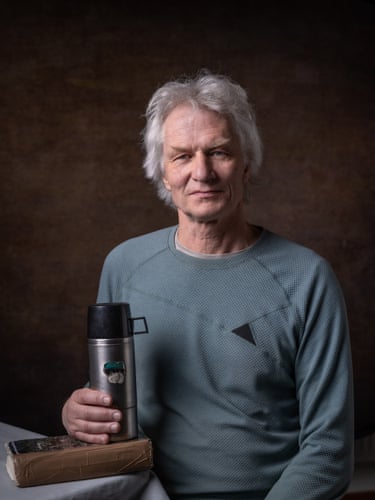 A man holds a flask that rests on a book