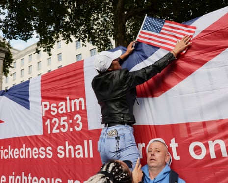 A person holds a US flag during a vigil at the Montgomery Statue in Whitehall, to commemorate conservative activist Charlie Kirk.
