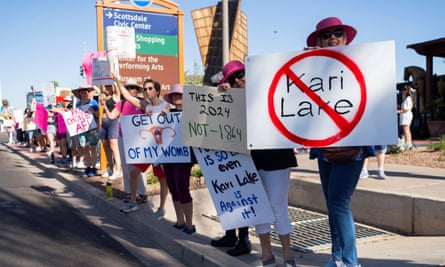 Women hold signs against Kari Lake, the Arizona Republican Senate candidate, during a protest on 14 April 2024.