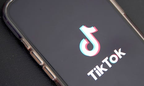 TikTok logo is displayed on a phone