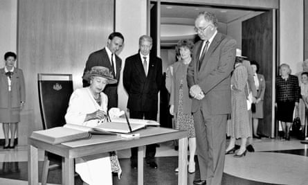 Queen Elizabeth II signs the visitors’ book at Parliament House in Canberra in February 1992 while prime minister Paul Keating and officials look on.