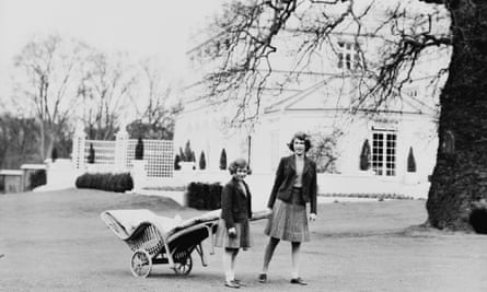 Princesses Elizabeth (R) and Margaret pulling a lawn chair on wheels at the Royal Lodge in April 1940.