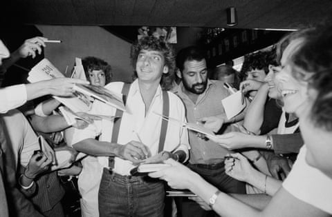 Black and white image of Barry Manilow surrounded by autograph hunters