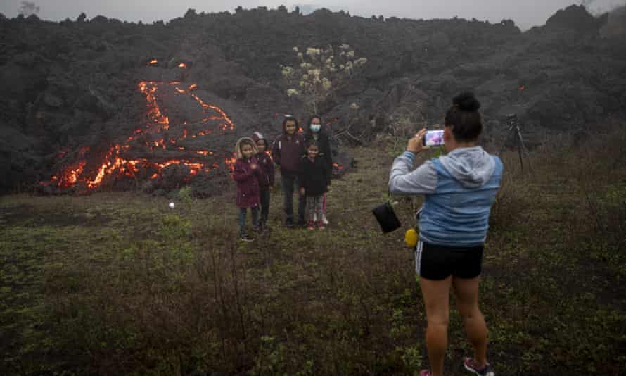 Los miembros de la familia posan para fotos cerca de la lava que fluye del volcán Pacaya cerca de la aldea El Patrocinio.