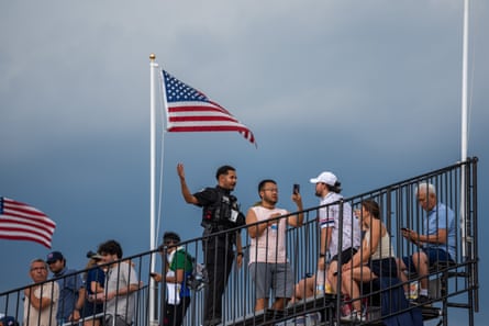 A police officer tells attendees to leave as a storm rolls in