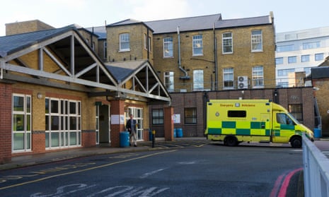 The entrance to a hospital with an ambulance parked outside