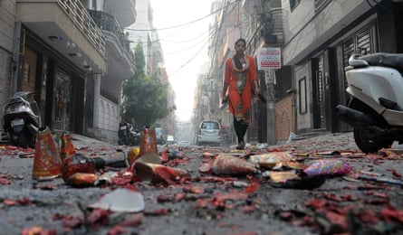 An Indian girl passing the street littered with spent crackers at day after the Diwali in New Delhi.