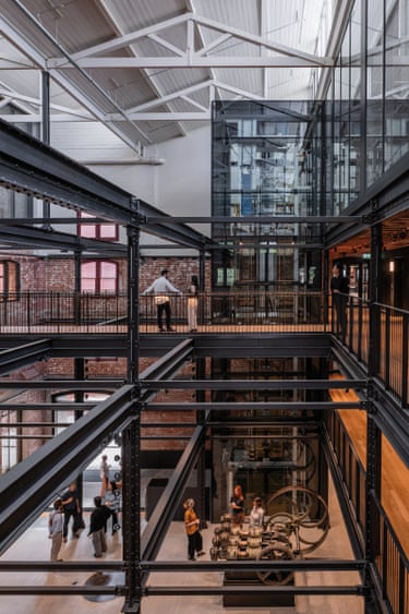 People stand on multiple levels of the converted Younghusband building, with exposed steel beams and brick walls