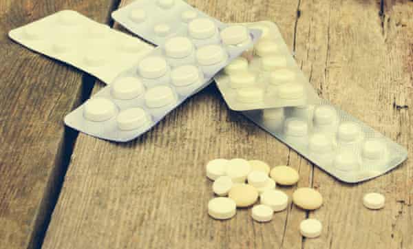 Pills on old wooden background.
