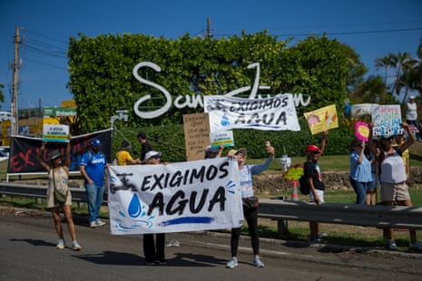 Protesters on a road hold signs saying ‘Exigimos Ague’ Protesters on a road hold signs saying ‘Exigimos Ague’