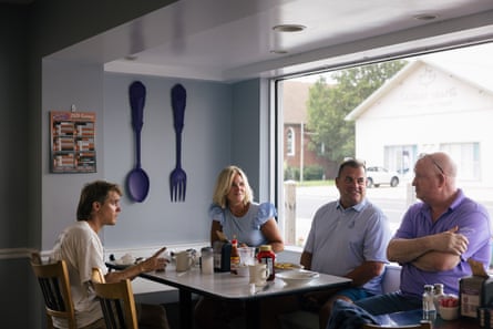 A family and their friend chat around a restaurant table