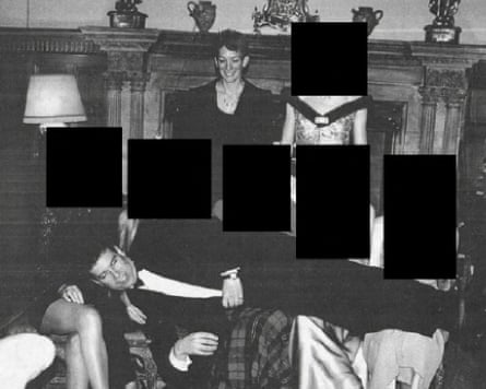 Black and white picture of Maxwell looking on as Andrew lays across the laps of women sitting on chairs