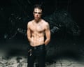 Yungblud poses shirtless with black wings sprouting from his back