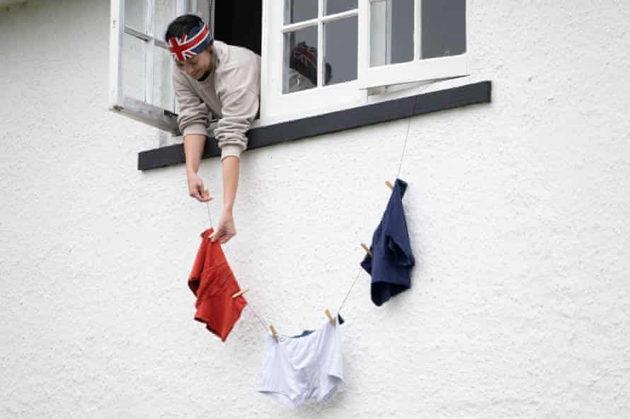 Una mujer cuelga pantalones con los colores de la bandera de la Unión desde su ventana en Rhobina el 5 de junio de 2022 en Cardiff, Gales.