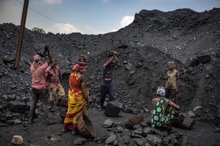 Workers break up coal before carrying it in baskets to waiting lorries.