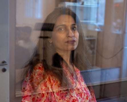 Fatemeh, a woman with dark hair, pictured behind some glass
