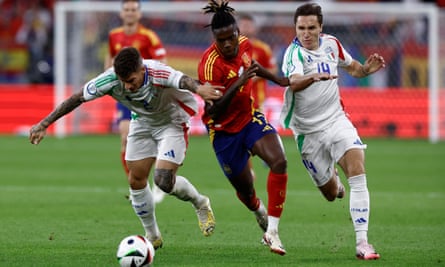 Spain’s midfielder Nico Williams (centre) goes for the ball with two Italy defenders