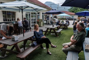 People sit on picnic benches outside Lured Market & Grill