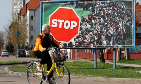 A woman cycles past an anti-immigration election poster for Victor Orbán’s Fidesz party before April’s election.